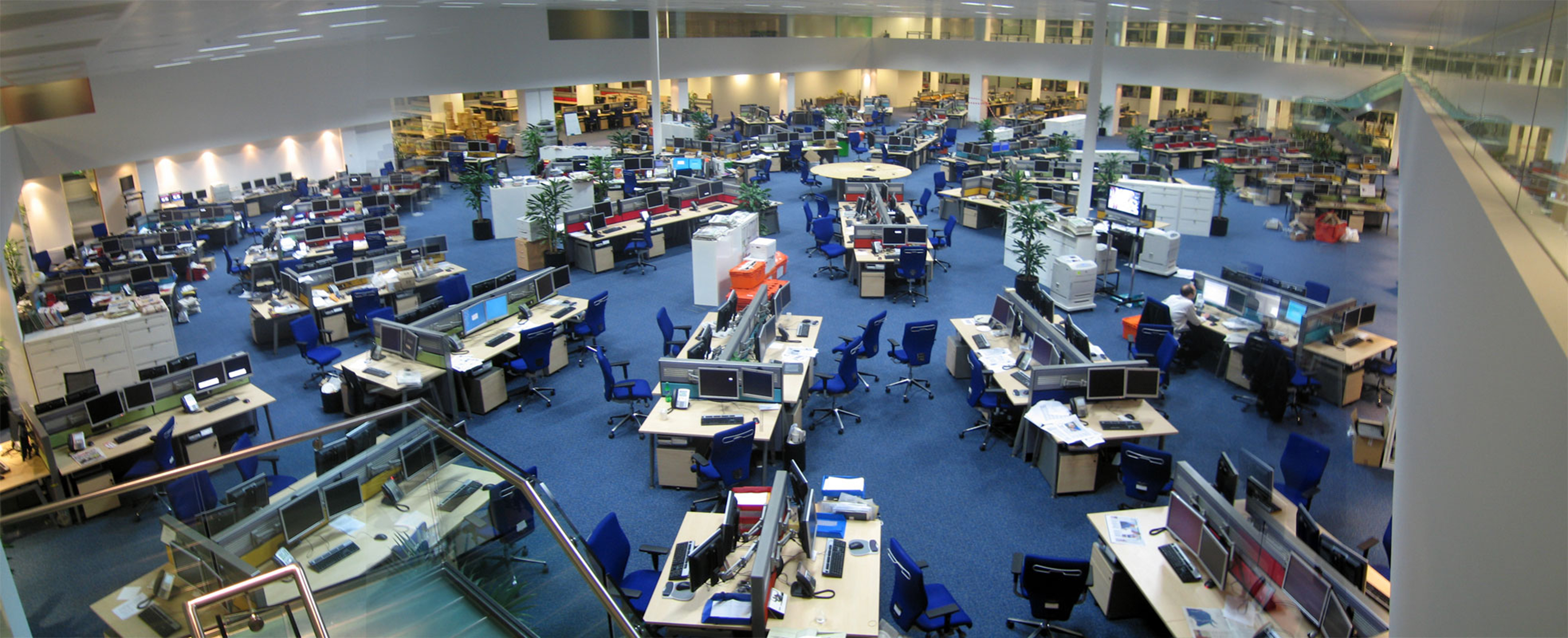 Esta foto muestra una gran sala de noticias abierta con suficiente espacio para sentar a unos 200 empleados.